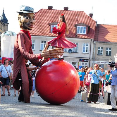 Stelzenläufer mit Ball und Tänzerin beim Umzug im Rahmen der Europatage 2015 in Szamotuly, Polen.