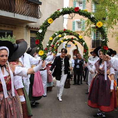Menschen in traditioneller Tracht stehen beim Stadtfest in Brignoles, Frankreich Spalier.