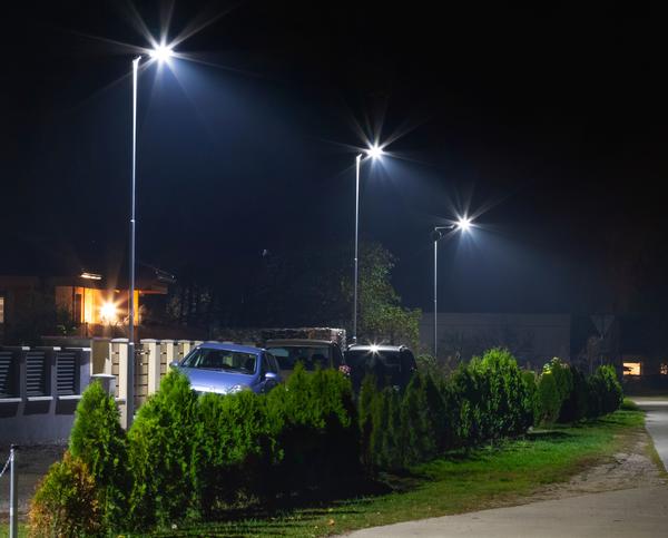 Laternen mit LED-Lampen erhellen eine nächtliche Wohnstraße.