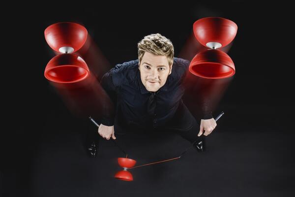 Axel Schiel als Diabolo-Jongleur mit drei roten Diabolos in der Luft.