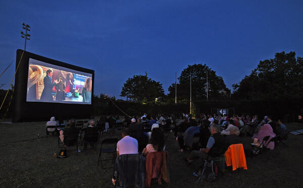 Open-Air-Kino 2021: Besucher schauen sich einen Film auf der großen Leinwand im Sportpark an.