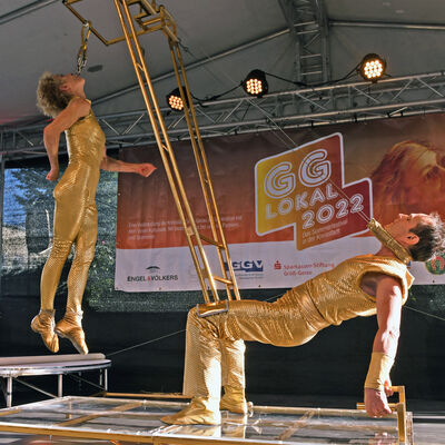 Zwei Artisten in goldenen Anzügen mit ihrem Balanceakt auf der Bühne des Sommerfestivals GG LOKAL in Groß-Gerau.