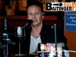 Pressefoto von Musiker Ralf Baitinger am Mikrofon.