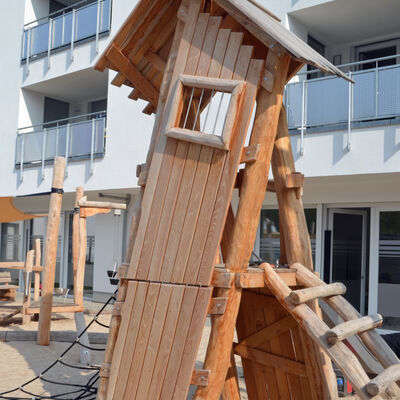 Ein aus Holz bestehendes Kletterger&uuml;st im Au&szlig;enbereich einer Kita.