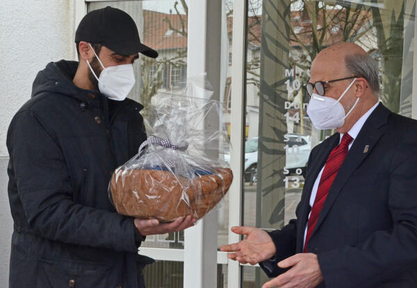 Bürgermeister Erhard Walther (rechts) übergibt das Dankeschön-Geschenk der Stadt an Nassid Wagishauser (links) von der Ahmadiyya Muslim Jamaat in Groß-Gerau.