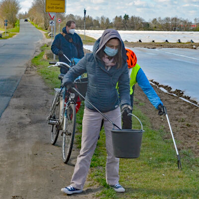 Teilnehmer des Umwelttages sammeln achtlos weggeworfene Abfälle auf dem Weg zum Hegbachsee.