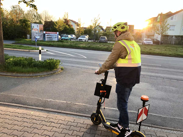 Unter Einsatz eines E-Scooters, der mit hochauflösenden Kameras ausgestattet ist, erfasst ein Straßenbauingenieur den Zustand von Fuß- und Radwegen.