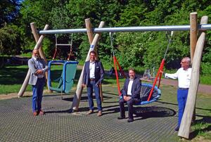 Das Bild zeigt die Schaukelanlage für Menschen mit Handicap. Davor stehen (von links) Bürgermeister Erhard Walther, vom Rotary-Club Henning Fischer, Karl Norbert Merz und Wilfried J. Ehrlich.
