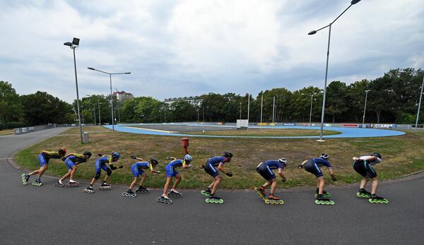 Acht aufgereihte Speedskater in einer Kurve auf der Anlage in Gro&szlig;-Gerau.